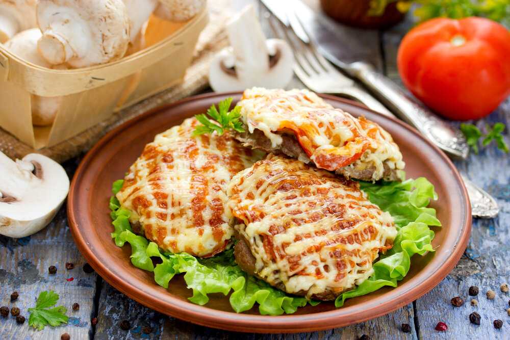 Свинина по-французски на сковороде с помидорами, сыром и грибами